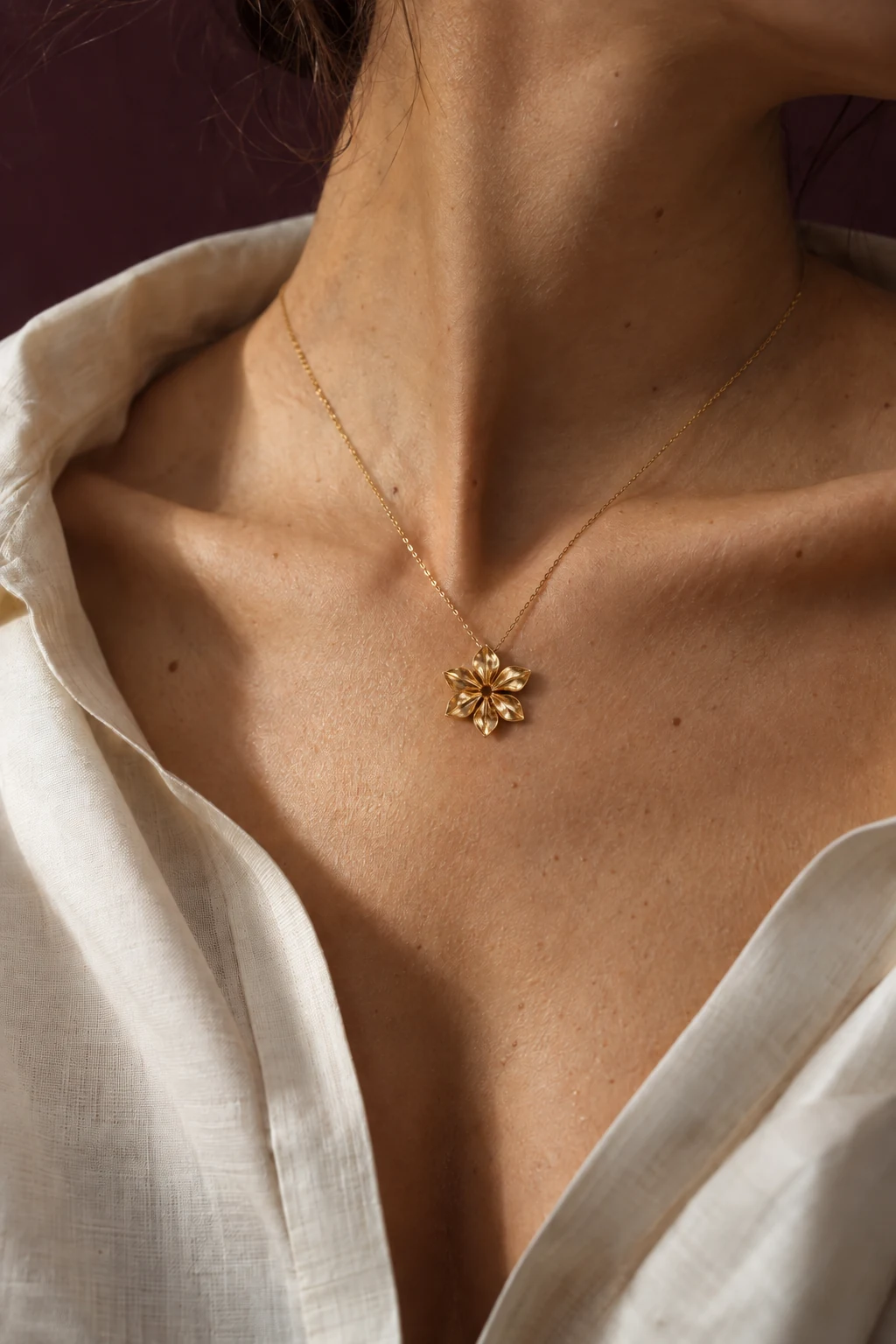 Illustrative editorial study of a delicate flower pendant against an ivory neckline